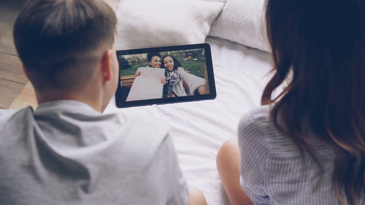 Family using a smart display tablet for video calls with friends
