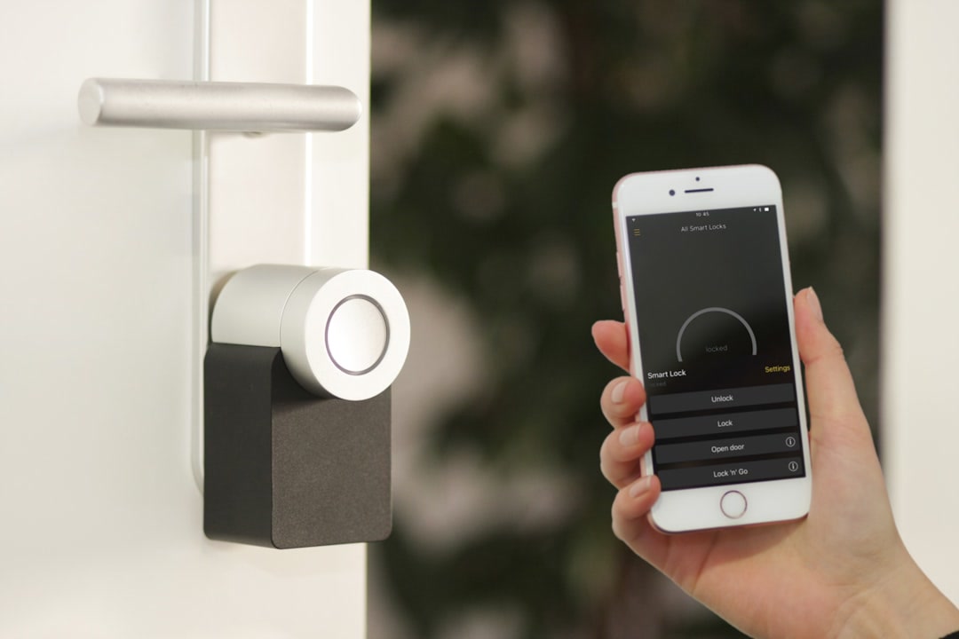A smart video doorbell mounted on the front door of a suburban home, viewed from the porch in late afternoon light, showing its camera lens and speaker grille