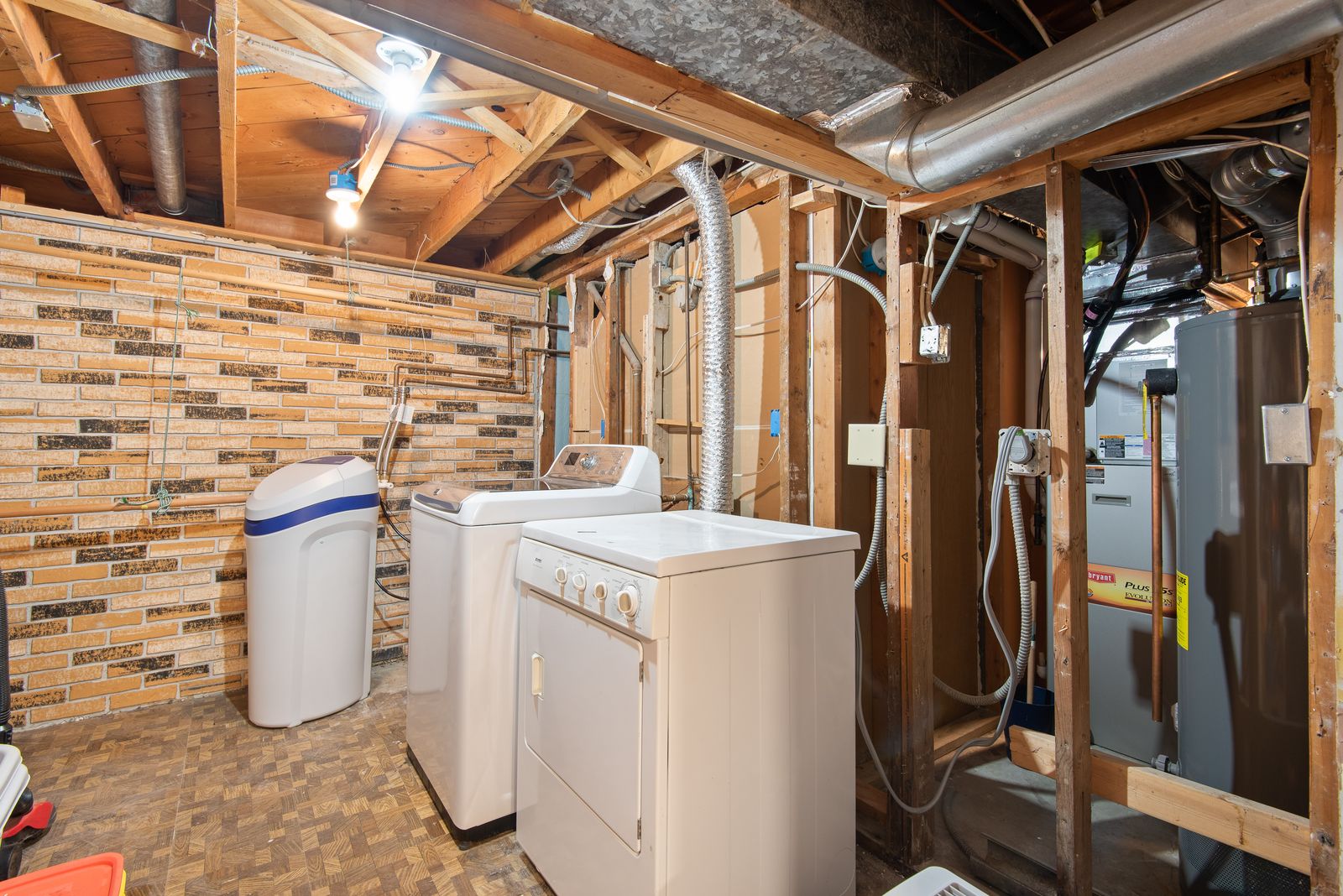 Basement utility room with washing machine, dryer, and water heater