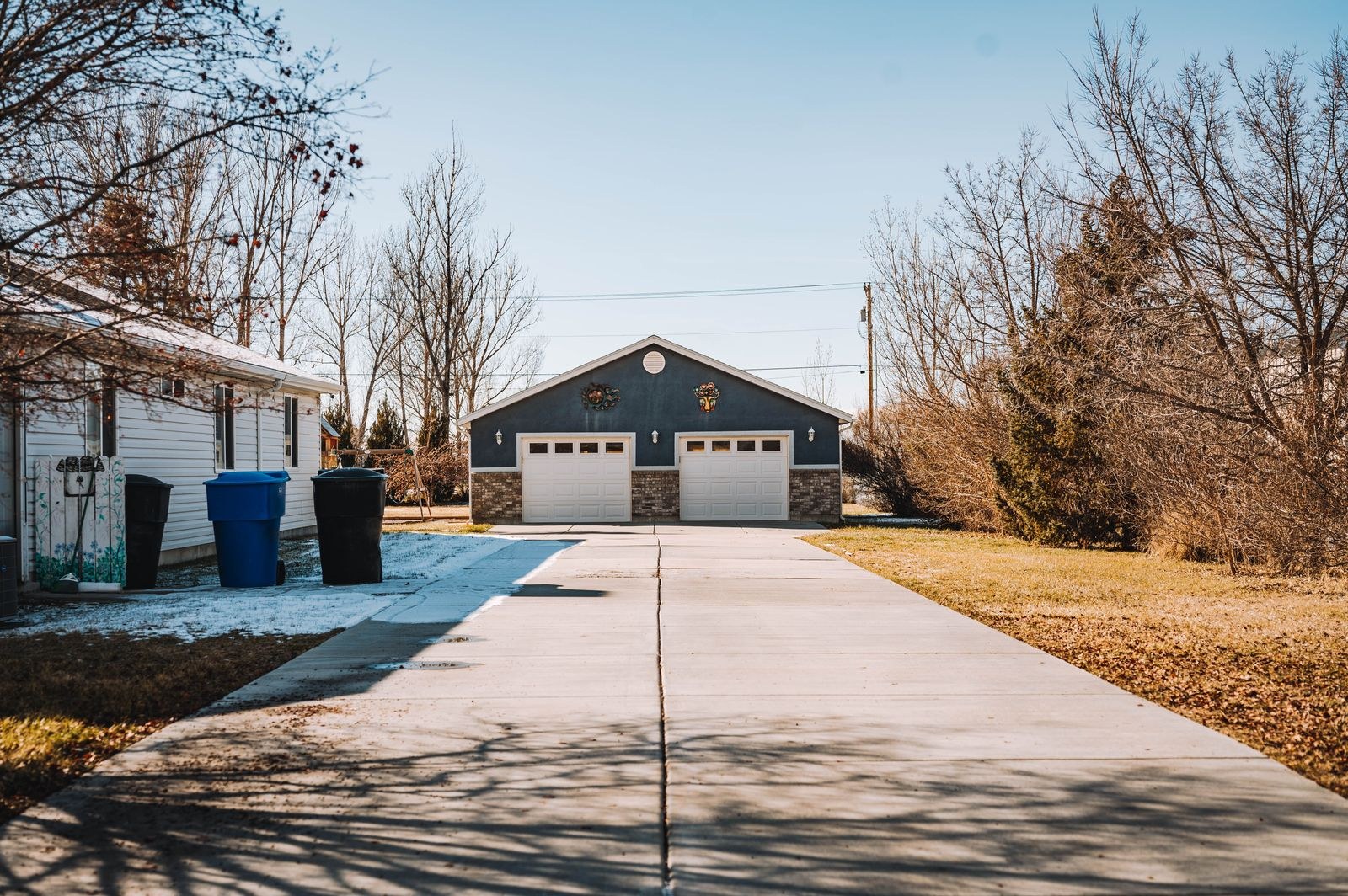 Suburban driveway leading to a house and garage doors