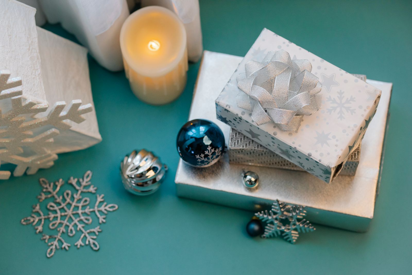 Wrapped silver and white Christmas gift boxes with holiday ornaments