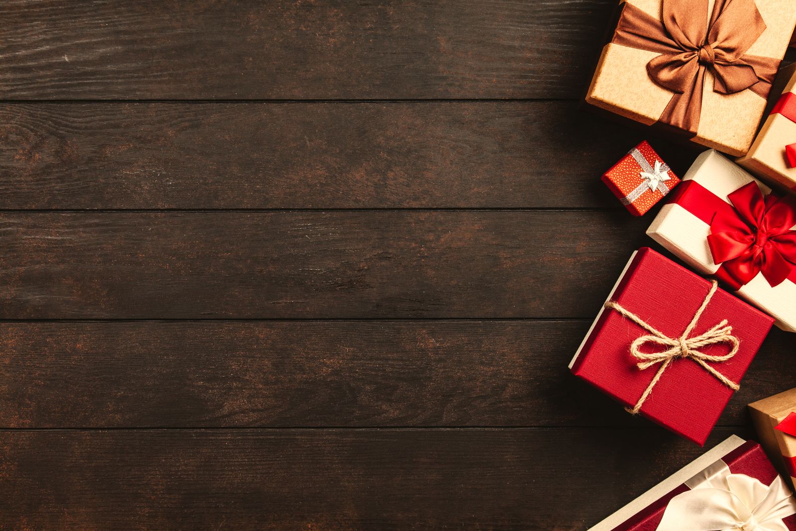 Holiday gift boxes with ribbons on a rustic wooden surface