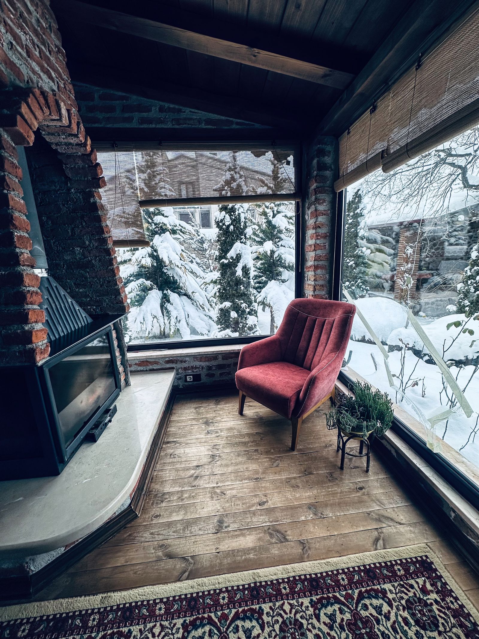 Cozy armchair by a fireplace with a snowy view outside